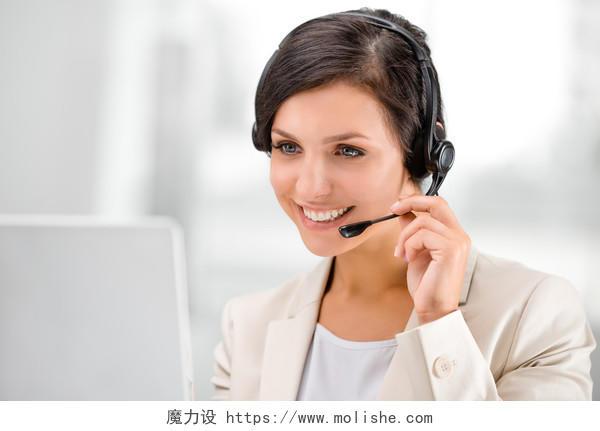 美丽微笑的女人戴着耳机在呼叫中心咨询时使用笔记本电脑客服人员美女客服